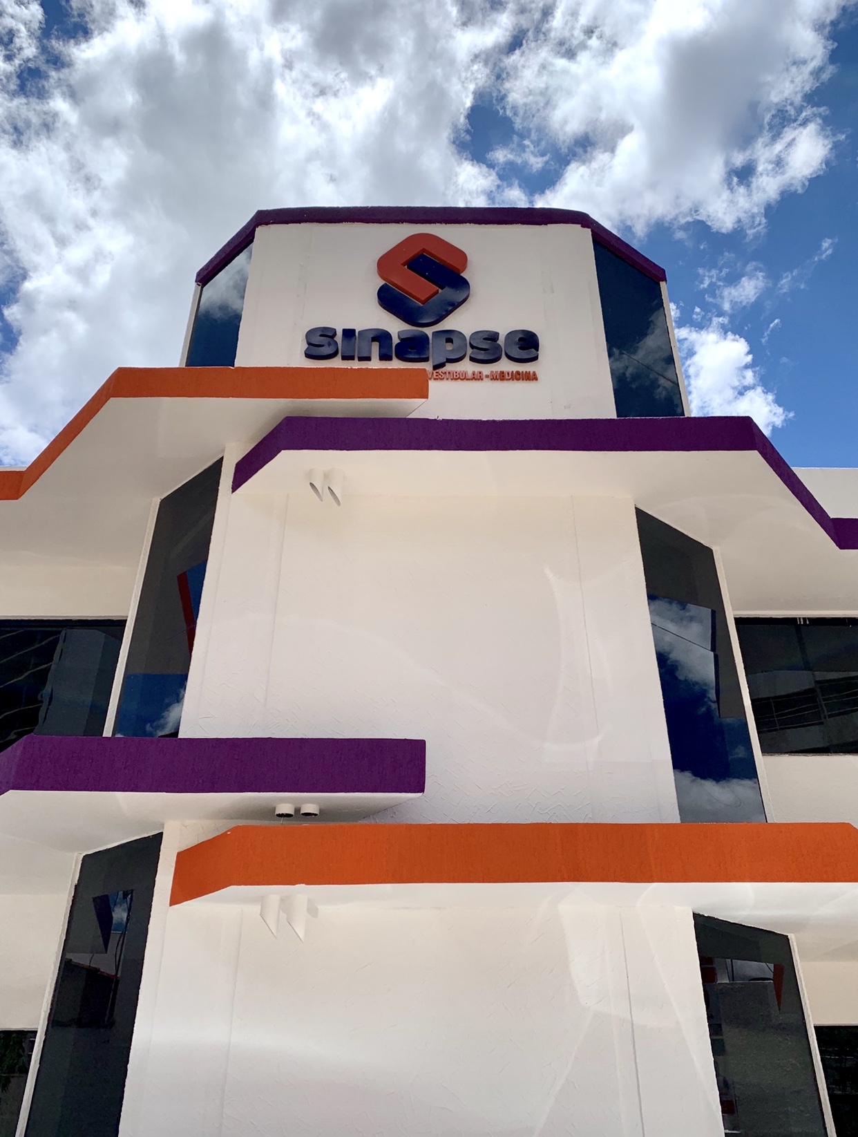 Fachada do Colégio Sinapse com detalhes em roxo e laranja